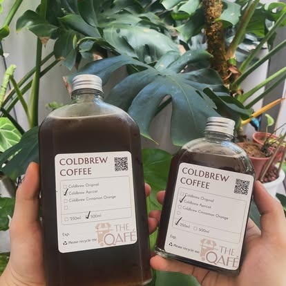 Hai tay cầm chai coldbrew 500 ml và 250 ml của The Qafé