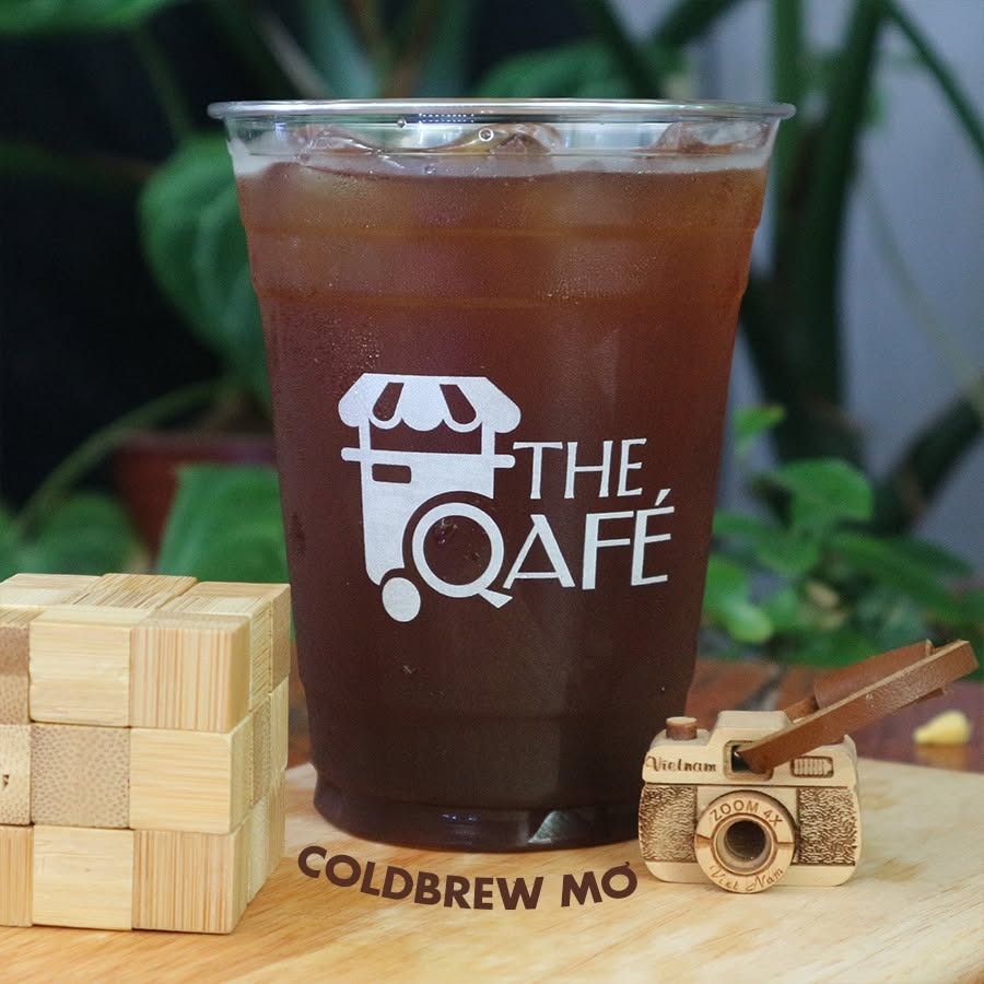 Ly Coldbrew Mơ của The Qafé trên tấm thớt gỗ